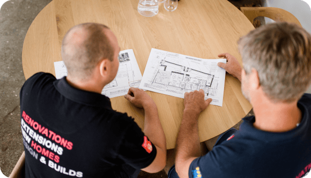 Two men looking over house design plans.